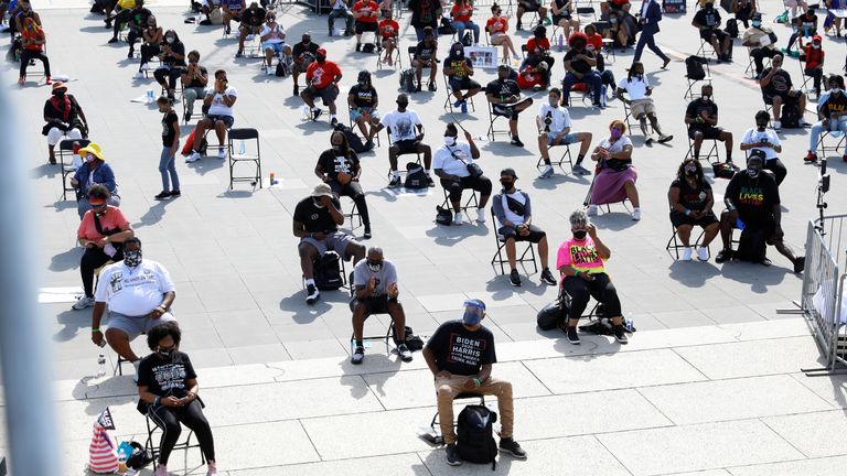 Demonstrators sit in chairs set out for social distancing at the Lincoln Memorial 