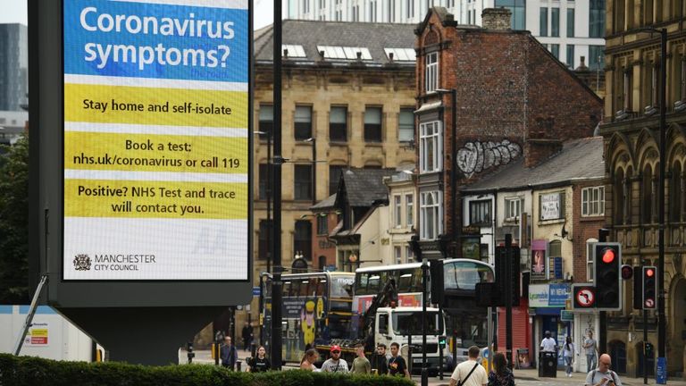 A large electronic billboard displays a message listing the actions that must be taken if you have symptoms of COVID-19, the disease caused by the novel coronavirus, in Manchester, northwest England, on July 31, 2020. - Britain today "put the brakes on" easing lockdown measures and imposed new rules on millions of households in northern England, following concerns over a spike in coronavirus infections. (Photo by Oli SCARFF / AFP) (Photo by OLI SCARFF/AFP via Getty Images)