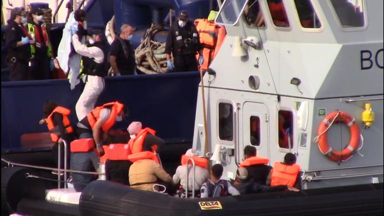Migrants being taken off boat after being rescued by coastguards