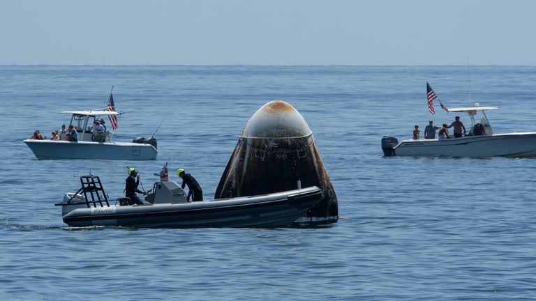 Support teams arrived at the spacecraft just after it landed, with members of the public in private boats looking on