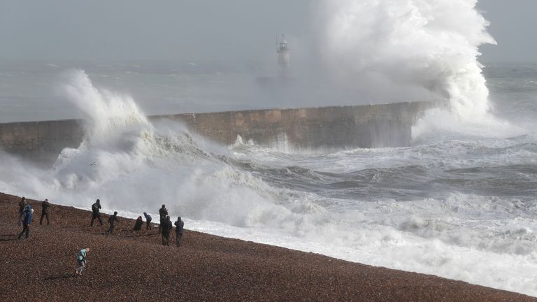 Waves crash over a lighthouse in Newhaven. Beaches are not expected to be packed amid chilly conditions in the UK