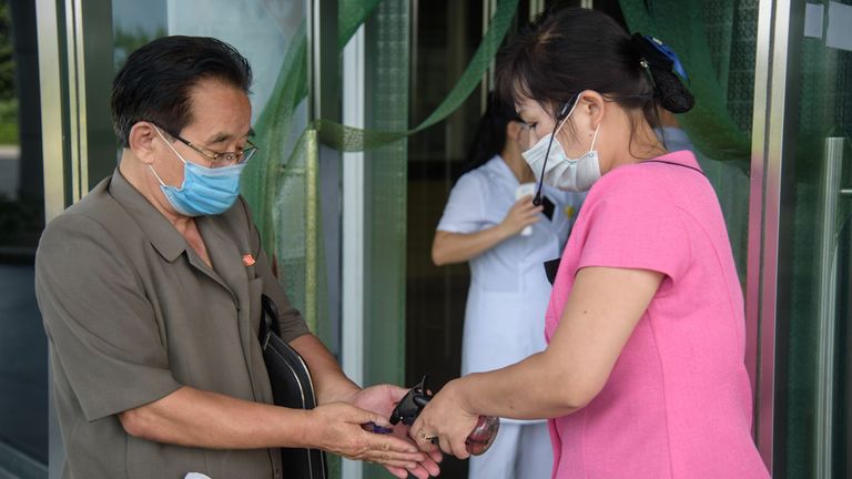A visitor is given hand sanitiser as he enters Ryugyong Health Complex in Pyongyang