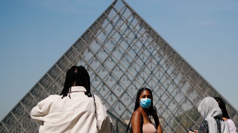 A woman wears a face mask outside the Louvre in the French capital