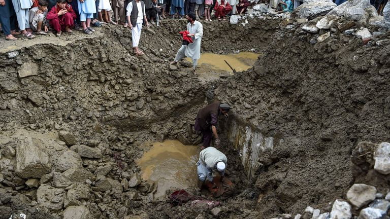 Villagers and rescuers search for bodies among households' debris