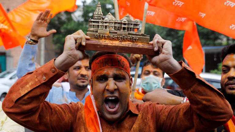 A supporter of the ruling Bharatiya Janata Party holds a model of the proposed temple in Ayodhya to celebrate the stone-laying ceremony