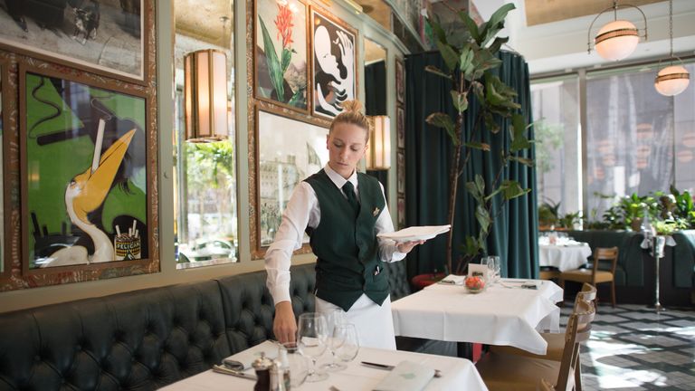 Staff at The Ivy Victoria in London prepare the dining area as the government initiative ends