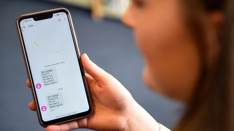 A pupil at Stonlelaw High School in Rutherglen, Glasgow receives a text message with her exam results on her mobile phone on August 4, 2020. - Exams were cancelled in Scotland due to the coronavirus pandemic and pupils have been awarded grades based on assessment. (Photo by Andy Buchanan / POOL / AFP) (Photo by ANDY BUCHANAN/POOL/AFP via Getty Images)
