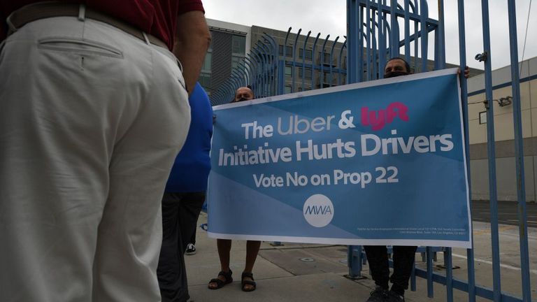 Rideshare drivers demonstrate against rideshare companies Uber and Lyft during a car caravan protest on August 6, 2020 in Los Angeles. - The drivers, organized by the Mobile Workers Alliance and Rideshare Drivers United unions, say Uber and Lyft&#39;s are pushing a "deceptive" November ballot initiative, which, if passed, they claim would "rewrite labor law" and turn app-based drivers into independent contractors, exempting companies such as Lyft and Uber from standard wage and hour restrictions. (P