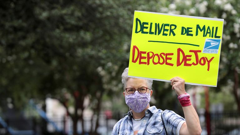 A protester holds a sign opposing US postmaster general Louis DeJoy