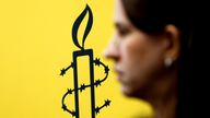 The logo of Amnesty International is seen next to director of Mujeres En Linea Luisa Kislinger, during a news conference in Caracas