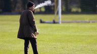 The Croatia national football team manager Slaven Bilic smokes a cigarette as he watches a training session at the club&#39;s facility outside Southampton (2007). 