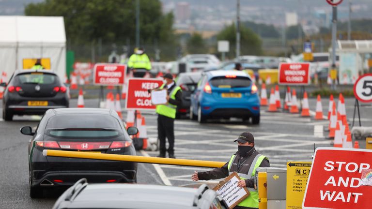 GLASGOW, SCOTLAND - AUGUST 26: An employee directs members of the public drive into a coronavirus testing centre at Glasgow Airport on August 26, 2020 in Glasgow, Scotland Covid – 19 testing capacity is to be increased in Scotland following a spike in demand, the First Minister announced that new mobile testing units would be deployed later this week. (Photo by Jeff J Mitchell/Getty Images)