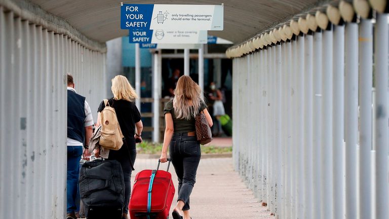 Travelers pull their suitcases when they arrive at London Stansted Airport, northeast of London, on August 20, 2020, following the decision by British airline Easyjet to close its operations at the airport from August 31 (Photo by Adrian DENNIS / AFP) (Photo by ADRIAN DENNIS / AFP via Getty Images)