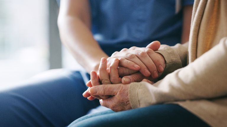 Cropped shot of a senior woman holding hands with a nurse