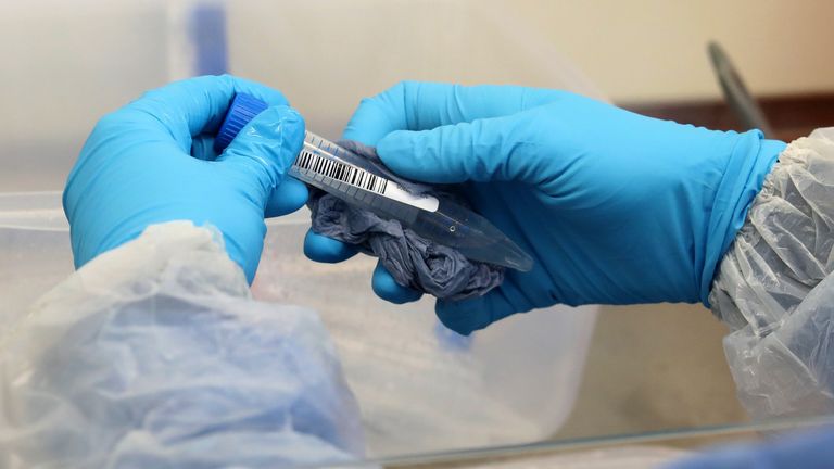 A laboratory technician wearing full PPE (personal protective equipment) cleans a test tube containing a live sample taken from people tested for the novel coronavirus, at a new Lighthouse Lab facility dedicated to testing for COVID-19, at Queen Elizabeth University Hospital in Glasgow on April 22, 2020. - The laboratory is part of a network of diagnostic testing facilities, along with other Lighthouse Lab sites in Milton Keynes and Cheshire, that will test samples from regional test centres around Britain where NHS staff and front-line workers with suspected Covid-19 infections have gone to have swabs taken for testing. (Photo by Andrew Milligan / POOL / AFP) (Photo by ANDREW MILLIGAN/POOL/AFP via Getty Images)
