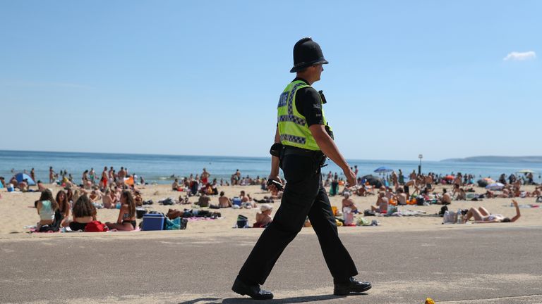 A police officer patrols along the beach in Bournemouth, Dorset, as the public are being reminded to practice social distancing following the relaxation of the coronavirus lockdown restrictions in England.