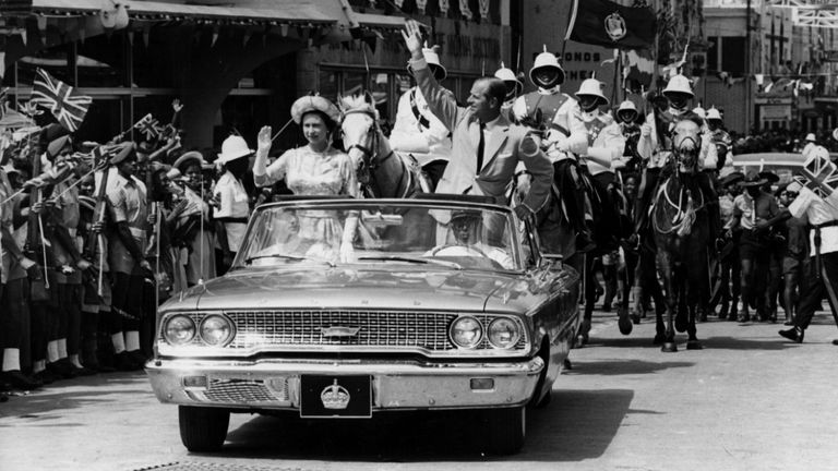 18th February 1966:  The Queen and Prince Philip driving through Barbados waving to the crowds.  (Photo by Keystone/Getty Images)