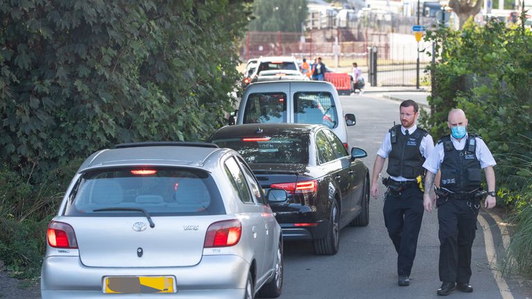 IMAGE PIXELLATED BY PA PICTURE DESK Police alongside queuing cars at a drive through test centre in Lewisham, south London.