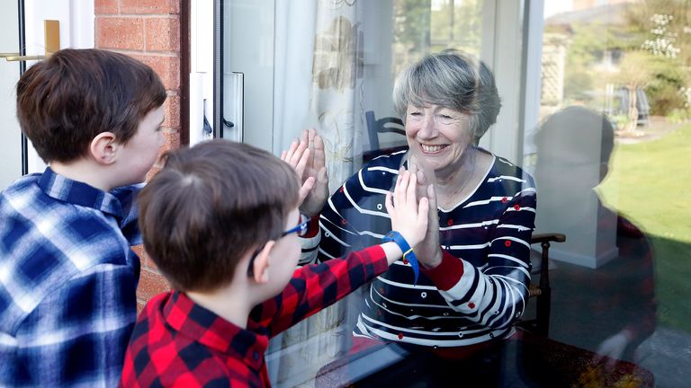 Ben and Isaac talk to their grandmother Sue through a window, as she and her husband Alan self-isolate due at their home in Knutsford, Cheshire.