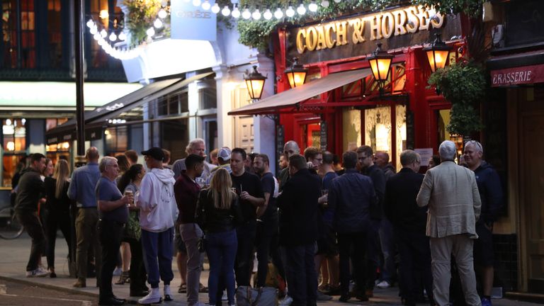 Young people outside the Coach and Horses pub in Wellington Street, London. People in England will be banned from meeting in groups of more than six from Monday as ministers try to tackle the rising number of coronavirus cases across the UK.