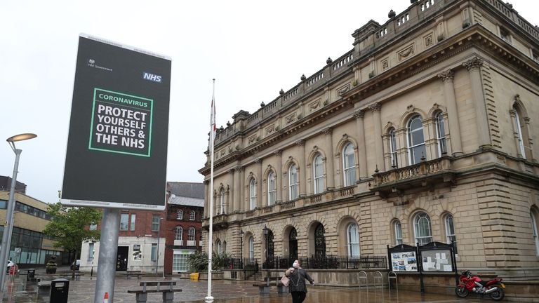 An advisory from the UK Government on a billboard in Blackburn town centre, as the town is facing a "rising tide" of coronavirus cases, centered on its large Asian community.