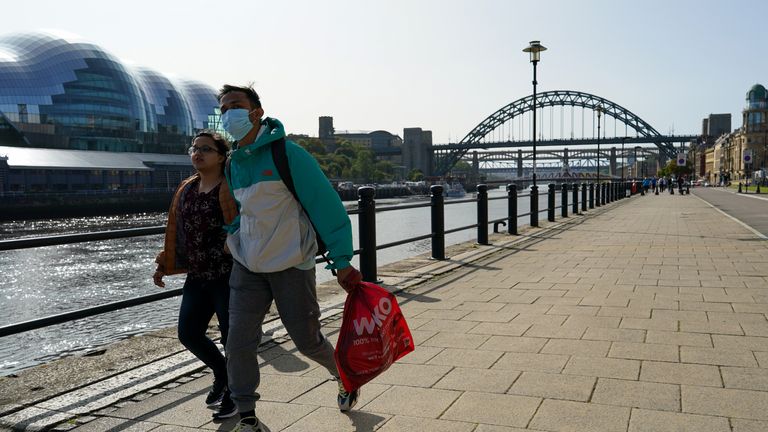 NEWCASTLE UPON TYNE, ENGLAND - SEPTEMBER 17: A couple walk along Newcastle quayside on September 17, 2020 in Newcastle upon Tyne, England. Almost two million people in north-east England will be banned from mixing with other households and pubs will close early as coronavirus cases rise. Health Secretary Matt Hancock announced the temporary restrictions will be in place from midnight due to concerning rates of infection. The measures affect seven council areas, Newcastle, Northumberland, North Tyneside, South Tyneside, Gateshead, County Durham and Sunderland. (Photo by Ian Forsyth/Getty Images)