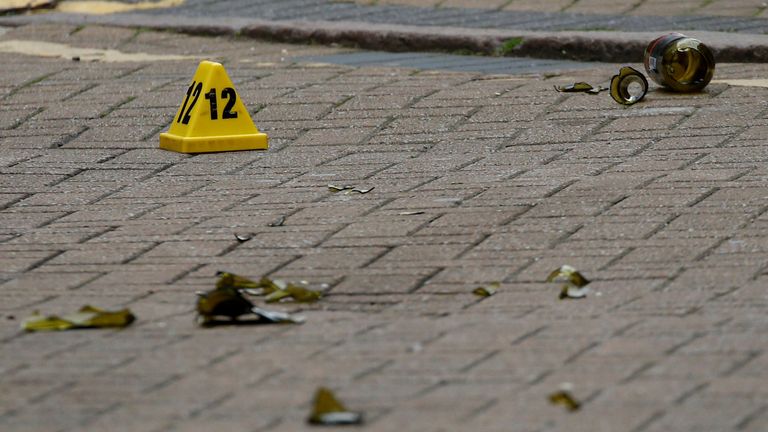 A broken glass bottle is seen near an evidence marker after reported stabbings in Birmingham, Britain