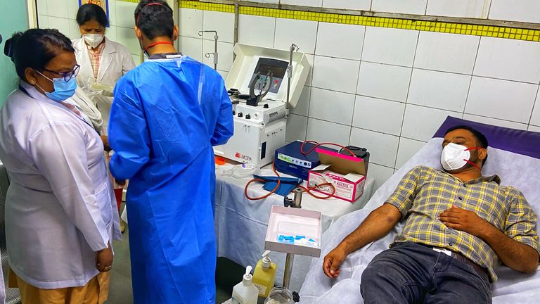 A man is seen donating blood at the hospital in Delhi