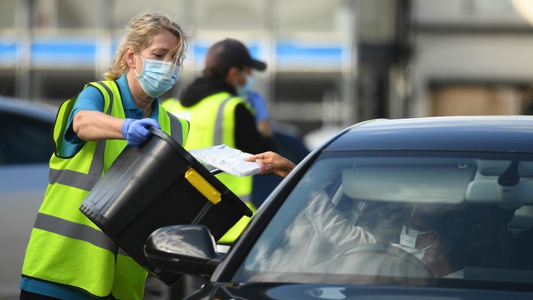 Workers collect completed COVID-19 tests at an in-car test center in Bolton, northern England, on September 9, 2020, as local lockdown restrictions were put in place due to an increase in cases of the new coronavirus in the city.  - The UK government, which controls health policy in England, imposed tougher restrictions on Bolton, near the northwestern city of Manchester, after a 