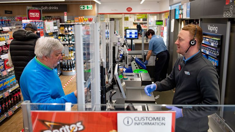 A clear screen divides employees and customers in store at a Co-op shop in Bromsgrove, Worcestershire