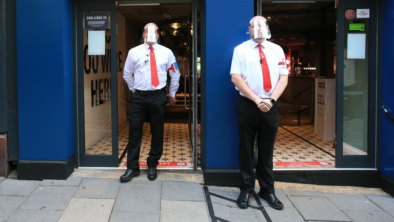 Bouncers wearing visors secure the entrance to a pub in Newcastle, northern England on July 4, 2020, as restrictions are further eased during the novel coronavirus COVID-19 pandemic. - Pubs in England reopen on Saturday for the first time since late March, bringing cheer to drinkers and the industry but fears of public disorder and fresh coronavirus cases. (Photo by Lindsey Parnaby / AFP) (Photo by LINDSEY PARNABY/AFP via Getty