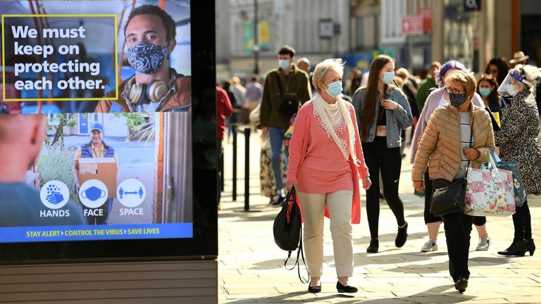 Shoppers, some wearing a face mask or covering, walk past an electronic billboard displaying a UK Government advert advising the public to take precautions to mitigate the spread of COVID-19, in Newcastle city centre, north-east England, on September 17, 2020. - The British government on Thursday announced new restrictions for northeast England, the latest region to see a surge in coronavirus cases as Prime Minister Boris Johnson warned of a &#34;second hump&#34; in nationwide transmission. Residents in
