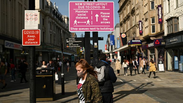 BRITAIN-HEALTH-VIRUS
Shoppers, some wearing a face mask or covering due to the COVID-19 pandemic, walk past a sign alerting pedestrians to a one-way system to assist with social distancing, in Newcastle city centre, north-east England, on September 17, 2020. - The British government on Thursday announced new restrictions for northeast England, the latest region to see a surge in coronavirus cases as Prime Minister Boris Johnson warned of a "second hump" in nationwide transmission. Residents in t