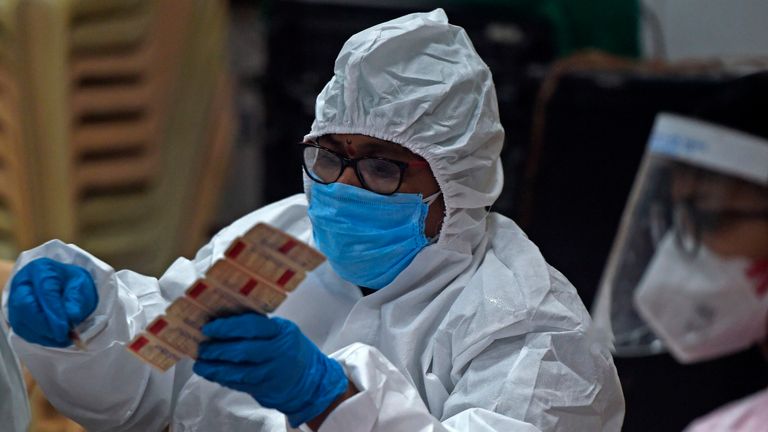 A medical volunteer distributes Vitamin tablets to people at a marriage hall, which is temporarily converted into a COVID-19 coronavirus testing centre, in Mumbai on July 17, 2020. - Coronavirus cases in India passed one million on July 17, official data showed as authorities struggle to check the spread of the deadly pandemic across the world&#39;s second-most populous nation. (Photo by Punit PARANJPE / AFP) (Photo by PUNIT PARANJPE/AFP via Getty Images)
