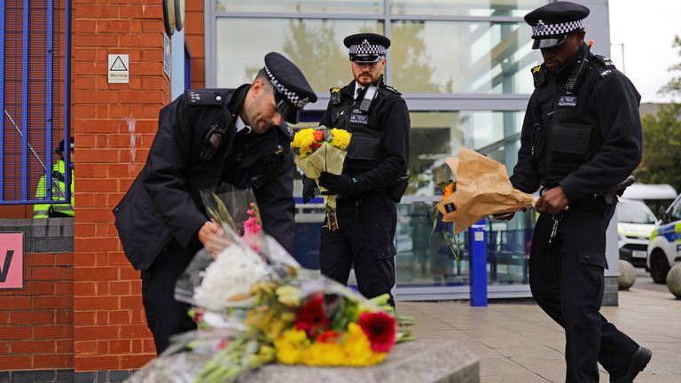 Police officers leave flowers outside Croydon Custody Centre in south London where a police officer was shot by a man who was being detained in the early hours of Friday morning. The officer was treated at the scene before being taken to hospital where he subsequently died. (Aaron Chown/PA)