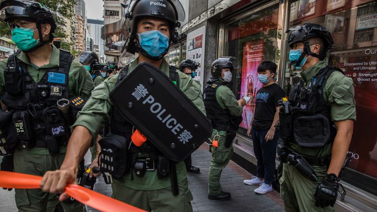 Police question a man as they patrol the area after protesters called for a rally in Hong Kong on September 6, 2020 to protest against the government&#39;s decision to postpone the legislative council election due to the COVID-19 coronavirus, and the national security law