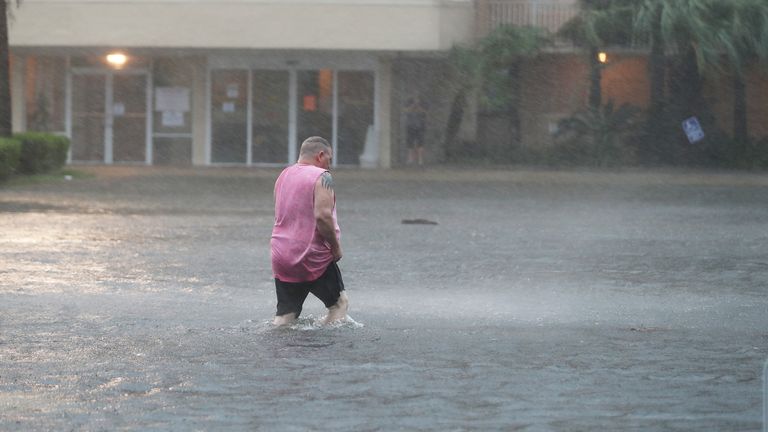 Hurricane Sally Makes Landfall On Gulf Coast GULF SHORES, ALABAMA - SEPTEMBER 15: A man walks though a flooded parking lot as the outer bands of Hurricane Sally come ashore on September 15, 2020 in Gulf Shores, Alabama. The storm is bringing heavy rain, high winds and a dangerous storm surge from Louisiana to Florida. (Photo by Joe Raedle/Getty Images)