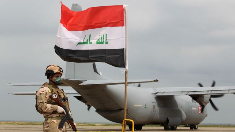 An Iraqi soldiers stands guard in front US military air carrier at the Qayyarah air base