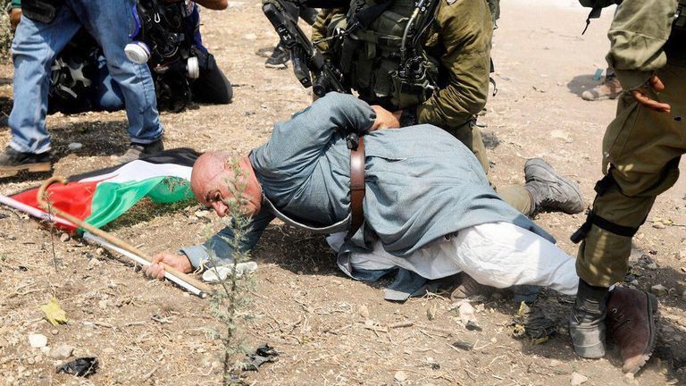 Khairi Hannoun being restrained by an Israeli soldier