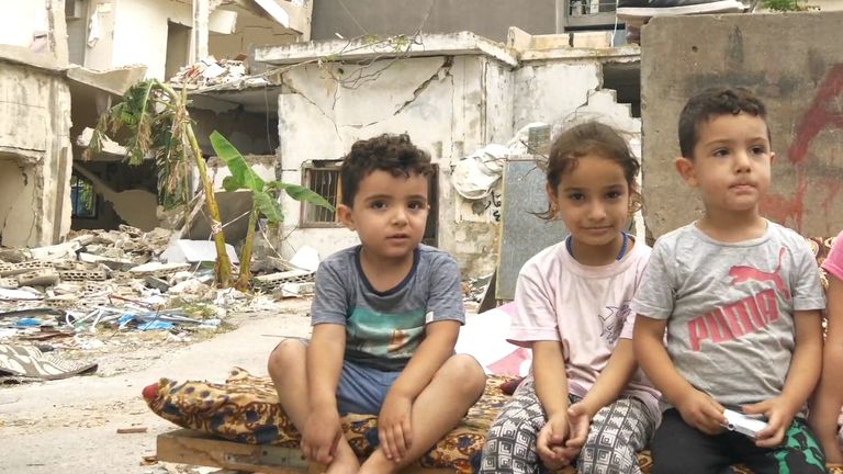 A Syrian refugee family sit in the ruins of their building, destroyed by the explosion in Beirut