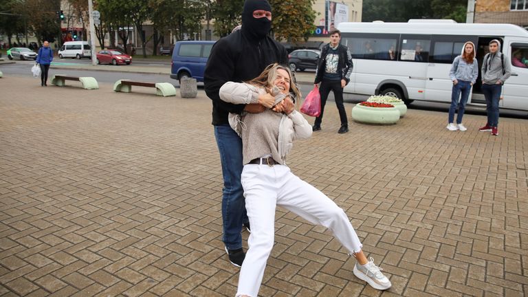 A law enforcement officer drags a demonstrator during a rally in support of detained Belarusian opposition leader Maria Kolesnikova in Minsk