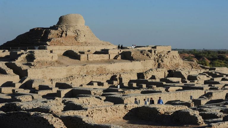 In this photograph taken on February 9, 2017, visitors walk through the UNESCO World Heritage archeological site of Mohenjo Daro some 425 kms north of the Pakistani city of Karachi. Once the centre of a powerful civilisation, Mohenjo Daro was one of the world&#39;s earliest cities -- a Bronze Age metropolis boasting flush toilets and a water and waste system to rival modern standards. Some 5,000 years on archaeologists believe the ruins could unlock the secrets of the Indus Valley people, who flouri