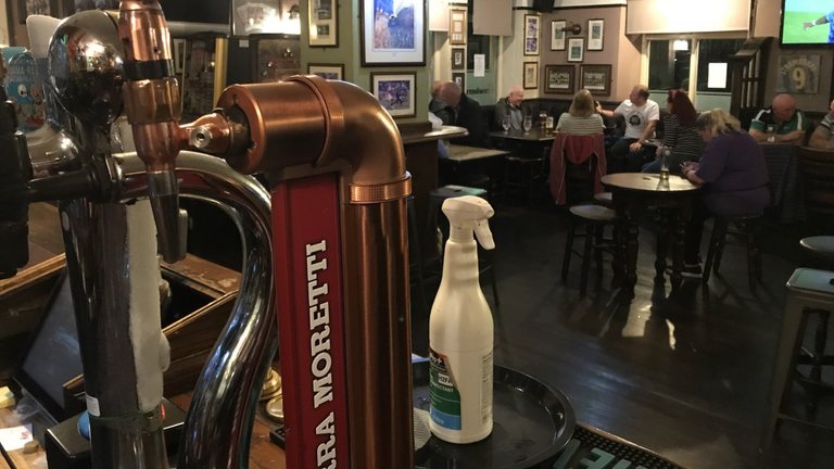 Beer pumps and disinfectant in the subdued Strawberry pub 