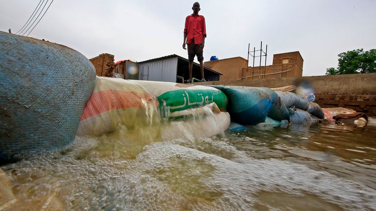 A Sudanese man stands behind a barricade amidst flood waters in Tuti island, where the Blue and White Nile merge between the twin cities of the capital Khartoum and Omdurman, on September 3, 2020