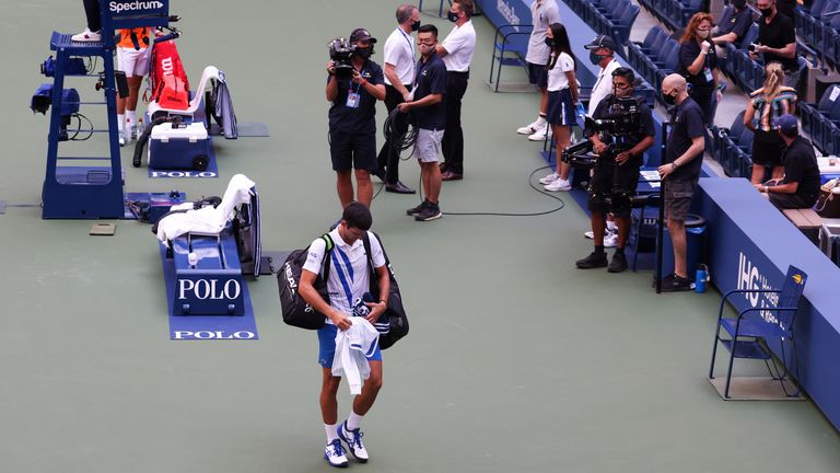 Novak Djokovic walks off court after being disqualified
