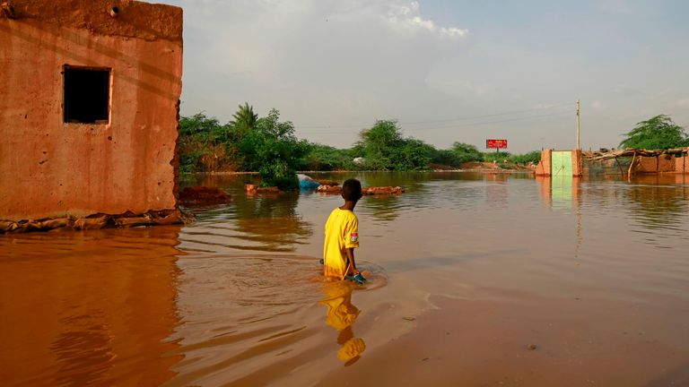  A Sudanese boy wades through a flooded street at the area of al-Qamayir in the capital&#39;s twin city of Omdurman, on August 26, 2020