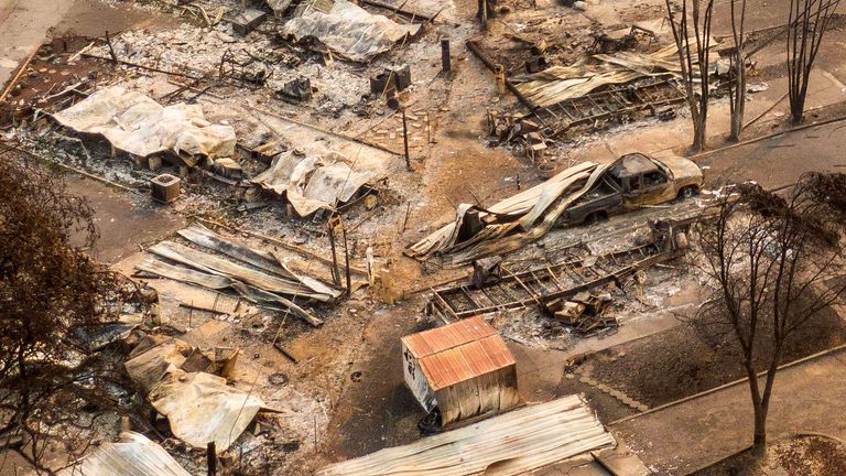 PHOENIX, OR - SEPTEMBER 10: In this aerial view from a drone, people walk through a mobile home park destroyed by fire on September 10, 2020 in Phoenix, Oregon. Hundreds of homes in the town have been lost due to wildfire. (Photo by David Ryder/Getty Images)