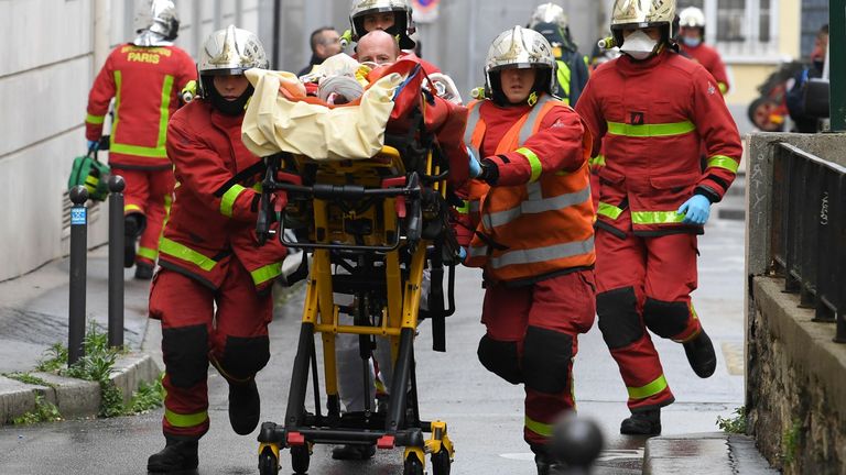 French firefighters push a gurney carrying an injured person near the former offices of the French satirical magazine Charlie Hebdo following an alleged attack by a man wielding a machete in Paris on September 25, 2020. - The threats coincide with the trial of 14 suspected accomplices of the perpetrators of the massacres at Charlie Hebdo and a Jewish supermarket that left a total of 17 dead. (Photo by Alain JOCARD / AFP) (Photo by ALAIN JOCARD/AFP via Getty Images)