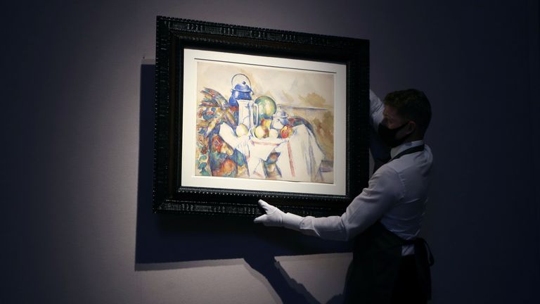 An employee holds a work by Paul Cezanne at Christie&#39;s auction house in London, Britain September 9, 2020. REUTERS/Tom Jacobs
