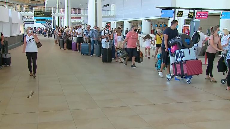 Passengers are seen queuing at Faro Airport in Portugal ready to return to the UK 